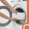 A person is placing a rolled-up white blanket into a washing machine. Podgląd zdjęcia produktu