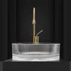 A clear studio shot of a glass sink with a gold faucet against a black background. Anteprima dell’immagine prodotto