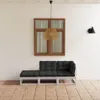 A three-piece outdoor lounge set with black cushions is placed on a tiled patio in front of a white wall with a wooden window and a hanging lamp. Produktbild-Vorschau