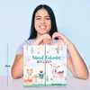 A young woman is holding an advent calendar with a winter-themed design featuring cartoon animals. Produktbild-Vorschau