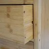 A close-up view of a wooden drawer unit, showing the texture and construction of the bamboo material. Produktbild-Vorschau