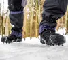 Close-up of a person's legs wearing crampons on hiking boots while walking on snow. Podgląd zdjęcia produktu