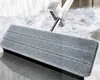 A close-up shot of a mop head and handle on a tiled floor. Podgląd zdjęcia produktu