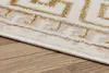 A close-up view of a rug with a geometric pattern on a wooden floor. Produktbild-Vorschau