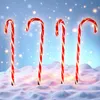 Four illuminated candy canes standing in snow with a bokeh background. Voir les images du produit