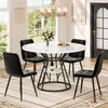 A dining room scene with a round marble-look table and four black velvet chairs, set against a backdrop of windows and a door. Produktbild-Vorschau