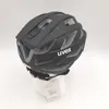 A black UVEX bike helmet is displayed on a white stand against a white background. Náhled obrázku produktu