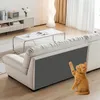 A cat is playing with a self-adhesive scratching mat attached to the side of a sofa in a living room. Produktbild-Vorschau