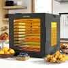A black COSTWAY food dehydrator with multiple trays filled with colorful sliced fruits and vegetables is shown on a white countertop. Several bowls of fresh fruits like oranges, blueberries, and a mix of apples and grapes are placed around the dehydrator. Podgląd zdjęcia produktu