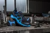 A pair of black and blue safety shoes are displayed on a workbench with tools. Náhľad obrázku produktu