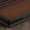 A close-up view of the corner of a dark brown leather phone case with a textured pattern and a black rubberized edge. The brand name 'TORRO' is embossed on the edge. Anteprima dell’immagine prodotto