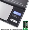 A black digital scale with a silver weighing platform and a digital display showing '0.00'. Two AAA batteries are shown next to the scale. Text indicates specifications and power supply. Produktbild-Vorschau