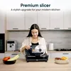 A woman using a slicer in a modern kitchen. Anteprima dell’immagine prodotto