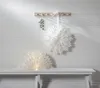 Two white paper star decorations are displayed against a white paneled wall, one hanging and one on a bench. Podgląd zdjęcia produktu