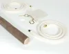 A wooden stick, two coiled ropes with gold fittings, a small drawstring bag, and two small white objects are arranged on a white surface. Produktbild-Vorschau