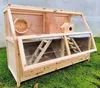 A wooden hamster cage with multiple levels and accessories, placed on grass. Produktbild-Vorschau