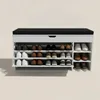 A white shoe cabinet with a black cushioned top, filled with various shoes on multiple shelves. Produktbild-Vorschau