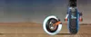 Close-up of an electric scooter wheel on a dirt road with a desert landscape in the background. Náhled obrázku produktu