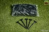A bag of black landscape staples is shown on a green artificial grass background, with five staples laid out in front of the bag. Náhľad obrázku produktu
