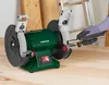 A person wearing a glove is using a bench grinder to sharpen a metal rod. Produktbild-Vorschau