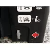 Close-up of a black plastic surface with instructional symbols and a lever. Produktbild-Vorschau
