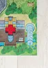 A close-up view of a colorful children's play rug depicting a town scene with a hospital, trees, and a road. Produktbild-Vorschau
