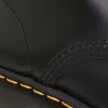A close-up view of the stitching and sole of a black boot. Náhled obrázku produktu