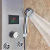 A close-up view of a modern stainless steel shower panel with a digital display showing temperature and timer, and a handheld showerhead spraying water. Náhľad obrázku produktu
