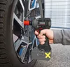 A person is using a cordless impact wrench to tighten a lug nut on a car wheel. Produktbild-Vorschau
