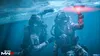 Two divers in tactical gear underwater, one holding a red light. Produktbild-Vorschau