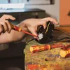 Hands working on electrical components with tools. Produktbild-Vorschau