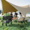 People sitting under a canopy at a table by a lake. Produktbild-Vorschau