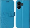A blue flip phone case with a floral and butterfly design is shown open, displaying the inside and the back of the case with the phone camera cutout. Produktbild-Vorschau
