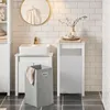 A bathroom scene with a sink, cabinet, and laundry hamper. Produktbild-Vorschau