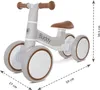 A light gray balance bike with brown accents and handlebars, shown from a side-angle on a white background. Dimensions are indicated with dashed lines and text. Náhľad obrázku produktu
