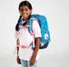 A young girl wearing a white t-shirt and blue jeans is shown from the waist up, wearing a blue backpack with pink accents and a cherry pattern. She is smiling at the camera. Anteprima dell’immagine prodotto