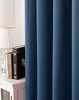 A close-up view of a dark blue curtain, with a bedside table and books visible on the left. Produktbild-Vorschau