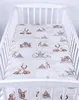 A crib sheet with a woodland animal pattern is laid out flat inside a white crib. Produktbild-Vorschau