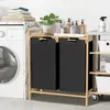 A laundry room scene with a washing machine, a bamboo laundry organizer with two black hampers, and various cleaning supplies. Náhled obrázku produktu