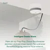 A smoke detector is mounted on a ceiling, with a stylized representation of smoke emanating from it and flowing towards a pendant lamp. Náhled obrázku produktu