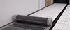 A roll of heating film is being unrolled onto a floor that has pre-installed heating elements. Produktbild-Vorschau