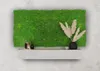 A moss wall panel displayed above a shelf with decorative items. Produktbild-Vorschau