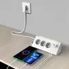 A white power strip with multiple outlets and USB ports is shown on a wooden desk, connected to a wall outlet. Two smartphones are charging from the power strip. Produktbild-Vorschau