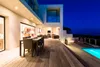 A modern house with a deck and pool at dusk. Anteprima dell’immagine prodotto