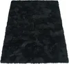 A black shaggy rug is shown from a diagonal angle on a white background. Produktbild-Vorschau