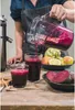 A person is pouring fresh beetroot juice from a blender into a glass, with other ingredients and a juicer visible. Náhľad obrázku produktu
