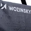 A close-up shot of a dark gray fabric with water droplets on it, showing a white logo and text. Produktbild-Vorschau