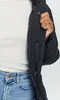 A close-up shot of a person wearing a black jacket and blue jeans. Produktbild-Vorschau