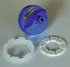 A blue cap with a yellow label and two white rings are arranged on a light gray surface. Voir les images du produit