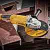 An angle grinder is placed on metal beams in a workshop or industrial setting. Produktbild-Vorschau